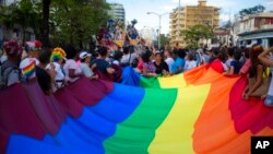 Masyarakat membawa bendera saat Parade LGBT tahunan di Havana, Kuba, Sabtu, 12 Mei 2018. (Foto: AP/Desmond Boylan)