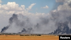 FILE - Smoke rises from Manbij city, Aleppo province, Syria, June 8, 2016. 