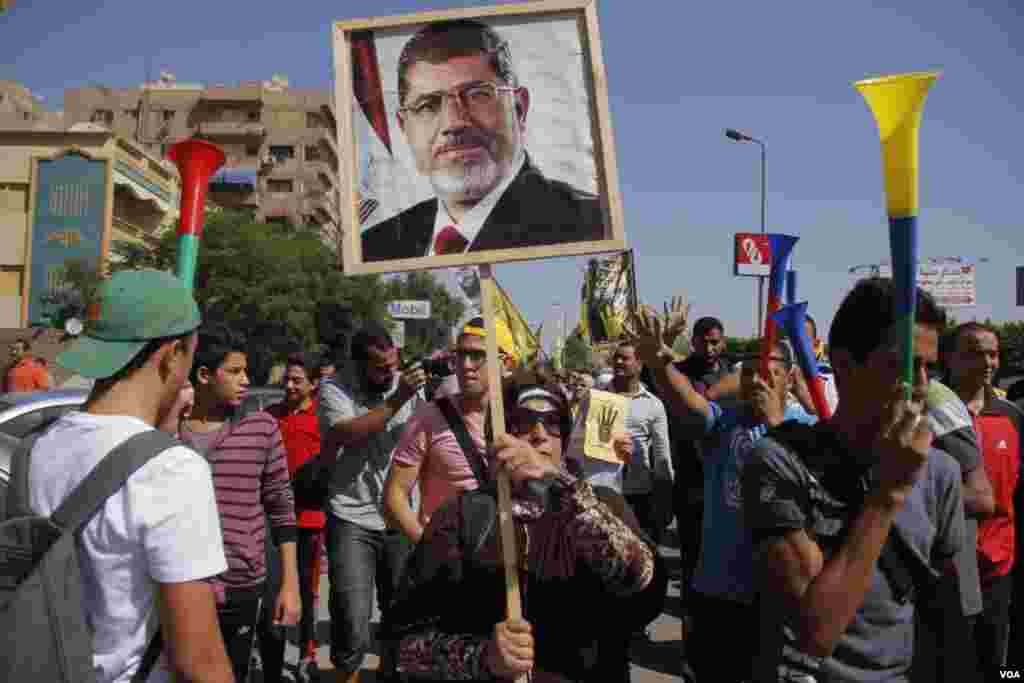 Protesters hold up a poster of ousted Egyptian President Mohamed Morsi, Nasr City, Cairo, Oct. 11, 2013. (Hamada Elrasam for VOA)