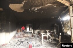 FILE - A man walks inside the U.S. consulate in Benghazi, which was attacked September 11 and set on fire by al-Qaida gunmen, Sept. 12, 2012.