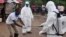 FILE - Health workers wash their hands after taking a blood specimen from a child to test for the Ebola virus in an area where a 17-year old boy died from the virus on the outskirts of Monrovia, Liberia, June 30, 2015. 