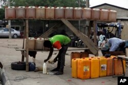 FILE - A man sells fuel on the road side in Kano, Nigeria, April 1, 2016. A fuel shortage in the country has created long lines at gas stations.