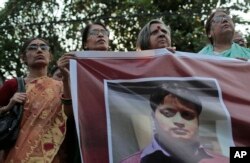 FILE - Bangladeshi social activists hold a banner displaying a portrait of blogger and author Ananta Bijoy Das during a protest against his killing, in Dhaka, Bangladesh, May 12, 2015.