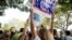 A supporter of Democratic presidential candidate Hillary Clinton attempts to block a Republican presidential candidate Donald Trump supporter from waving a sign as Clinton greets supporters outside an early voting station at the Pompano Beach Amphitheater