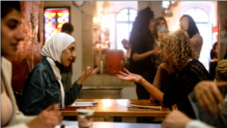 A Palestinian woman chats with an Israeli woman during a language exchange program modelled on speed dating, in Jerusalem, October 27, 2021. Picture taken October 27, 2021. REUTERS/Ronen Zvulun