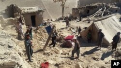 Pria Afghanistan membawa barang-barang mereka setelah gempa bumi di Provinsi Takhar, timur laut Kabul, Afghanistan, Selasa, 27 Oktober 2015. (Foto: AP)