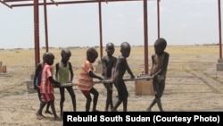 Everyone chipped in: the children of Jalle helped carry planks of wood to build the school.