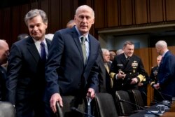 FILE - FBI Director Christopher Wray, left, and Director of National Intelligence Dan Coats, second from left, arrive for a hearing in Washington, Feb. 13, 2018.