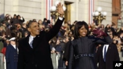 奥巴马夫妇走在宾夕法尼亚大道上时向民众挥手致意