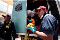 People stand in line to receive chicken as roadblocks have caused a food and fuel crisis, in La Paz, Bolivia, Nov. 18, 2019.