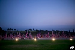 Visitors walk around the Pepperdine University's annual display of flags honoring the victims of the 9/11 terrorist attacks, Monday, Sept. 10, 2018, in Malibu, Calif.