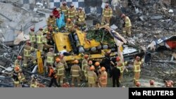 Petugas penyelamat Korea Selatan mencari para penumpang bus yang tertimpa reruntuhan gedung di Gwangju, Kamis (9/6). 