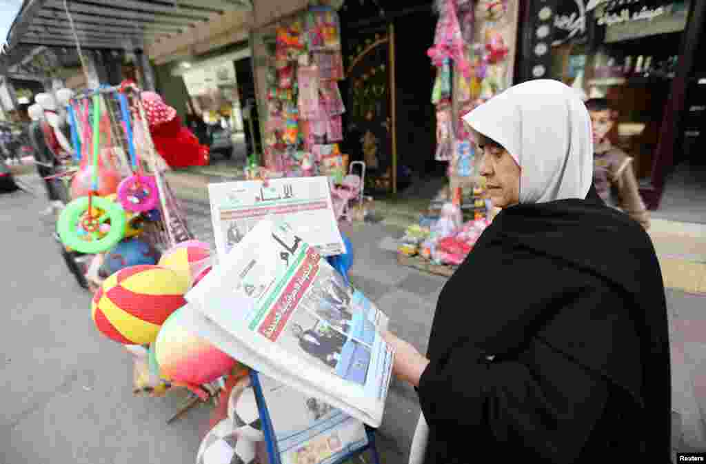 A Palestinian woman reads a local newspaper that features the Israeli election on its front page, in Khan Younis in the southern Gaza Strip, March 18, 2015.