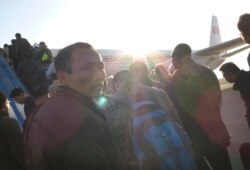 FILE - Foreigners and North Koreans, facing increased safety measures to prevent the possible spread of Ebola, board an Air Koryo flight bound for Beijing in Pyongyang, North Korea, Oct. 28, 2014.