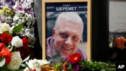 Foto Pavel Sheremet yang dikelilingi bunga dan lilin di tempat kematiannya (20/7). Kiev, Ukraina. (foto: AP Photo/Sergei Chusavkov)