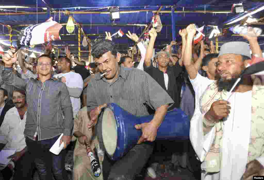 Supporters of former army chief Abdel-Fattah el-Sissi dance and wave Egyptian flags during a rally, in Sadat City, May 5, 2014.