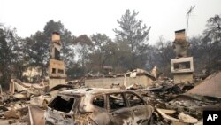 The burned remains of a car sit in the driveway of a home near the Silverado Country Club and Resort, Oct. 10, 2017, Napa, Calif.