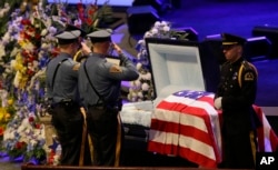 FILE - Law enforcement officer salute Dallas Police Sr. Cpl. Lorne Ahrens before his funeral service at Prestonwood Baptist Church in Plano, Texas, July 13, 2016.