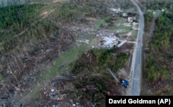 A truck, lower right, lies on its side in a neighborhood devastated by a tornado that saw multiple members of a family killed in Beauregard, Alabama, Tuesday, March 5, 2019.