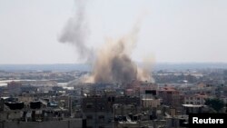 Smoke rises following what witnesses said was an Israeli air strike in Rafah in the southern Gaza Strip, Aug. 8, 2014.