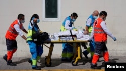 Petugas kesehatan mendorong tandu dengan pasien di unit gawat darurat di rumah sakit 12 de Octubre di tengah pandemi Covid-19, di Madrid, Spanyol, 2 September 2020.