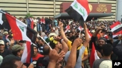 Para pendukung Ulama Syiah Muqtada al-Sadr mengibarkan bendera Irak di luar gedung parlemen di Zona Hijau. Baghdad, Irak.