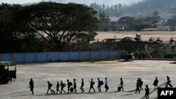 (FILES) "Waathirika" wa vituo vya utapeli huko Kyauk Khet nchini Myanmar wakiwa katika mstari wakienda kukutana na jeshi la Thai, Februari 12, 2025.