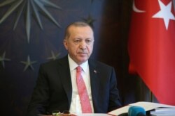 FILE - Turkish President Recep Tayyip Erdogan listens during a teleconference with his cabinet in Istanbul, May 11, 2020.