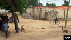 FILE - A man rides a bicyle in the town of Amchide, northern Cameroon, on the border with Nigeria, June 17, 2014. 