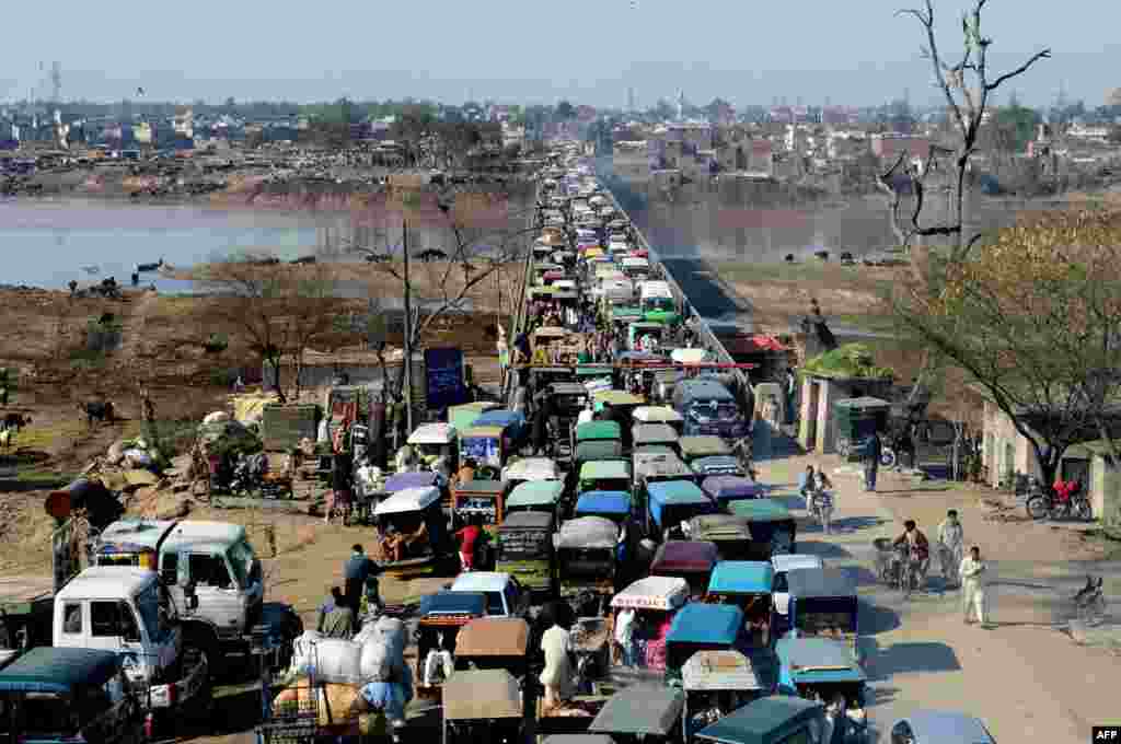Komuter di Pakistan terjebak dalam kemacetan lalu lintas di jembatan saat mereka memasuki Lahore.
