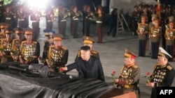 This picture taken early on July 27, 2021 and released from North Korea's official Korean Central News Agency (KCNA) shows North Korea's leader Kim Jong Un (C) visiting the Fatherland Liberation War Martyrs Cemetery in Pyongyang to mark the 68th anniversa