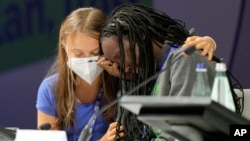 Ugandan climate activist Vanessa Nakate, right, is comforted by Swedish activist Greta Thunberg as she is overcome by emotion after speaking at the opening of a three-day Youth for Climate summit in Milan, Italy, Tuesday, Sept. 28, 2021. (AP Photo/Luca Br