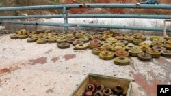 In this photo released by the Syrian official news agency SANA, landmines are collected by Syrian engineering troops from the M5 highway, recaptured by President Bashar Assad's forces this week, in Aleppo, Syria, Feb. 15, 2020.