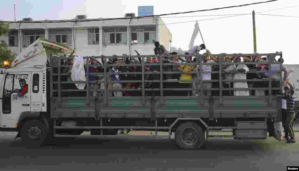Palestinians ride in a truck as they flee from Israeli shelling during an Israeli ground offensive east of Khan Younis in the southern Gaza Strip, July 24, 2014. 