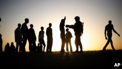 FILE - A French soldier checks passengers of a transport truck arriving in Gao, northern Mali, Feb. 14, 2013. 