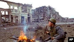 A Russian soldier lights a cigarette in the Chechen capital of Grozny, Sunday, in this March 19, 1995 file photo. (AP Photo/Shakh Aivazov, File)