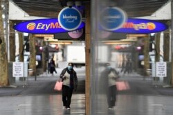 A pedestrian wears a face mask as the city operates under lockdown in response to an outbreak of the coronavirus disease (COVID-19) in Melbourne, Australia, Aug. 12, 2020. (AAP Image/James Ross via Reuters)