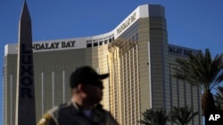 Seorang polisi Las Vegas berjaga di dekat area yang diblokir di dekat Mandalay Bay Resort and Casino, 3 Oktober 2017, dekat lokasi penembakan massa yang dilakukan oleh Stephen Craig Paddock di Las Vegas. (AP Photo/John Locher).