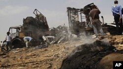 In this photo taken on a organized government tour, foreign journalists take photographs next to a damaged truck at the Hadba agricultural area, outside Tripoli, Libya, on June 8, 2011, which Libyan officials claim was a target of a NATO air strike.