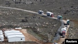 Des camions transportent les maisons préfabriquées lors de la démolition de la colonie illégale d'Amona en Cisjordanie occupée, le 6 février 2017.