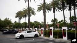 FILE - Tesla electric vehicles are charged at a charging station in Anaheim, Calif., June 9, 2023. 
