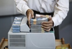 Seorang teller menumpuk Rupiah Indonesia di konter mata uang di dalam money changer di Jakarta. Banyak masyarakat yang terjerat pinjaman online ilegal yang sangat merugikan.(Foto: Reuters/Nyimas Laula)