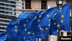 FILE - An EU flag flutters in the wind.