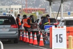 FILE - Workers for the U.S. federal government prepare the coronavirus disease (COVID-19) vaccines at a new mass vaccination center in Oakland, California, Feb. 16, 2021.