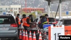 Workers for the U.S. federal government prepare the coronavirus disease (COVID-19) vaccines at a new mass vaccination center in Oakland, California, Feb. 16, 2021. 