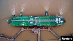 Sebuah kapal tanker pengangkut minyak mentah sedang sandar di terminal minyak mentah di Zhoushan, Provinsi Zhejiang, China, 4 Juli 2018.
