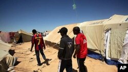 The three Ethiopian friends who survived more than two weeks adrift in the Mediterranean wander through Choucha Camp