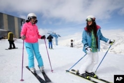 If you are lucky to live near a mountain, skiing is a great exercise. Here, Iranian skiers laugh at a ski resort north of the capital Tehran, Iran, March 2018.