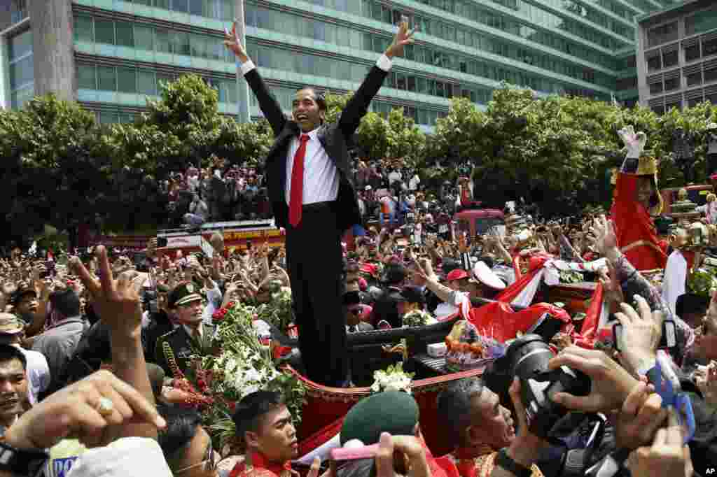 Indonesian President Joko Widodo gestures to the crowd during a street parade following his inauguration in Jakarta, Indonesia, Oct. 20, 2014.