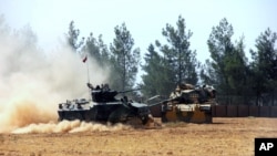 A Turkish army tank and an armored vehicle are stationed near the border with Syria, in Karkamis, Turkey, Aug. 23, 2016. 